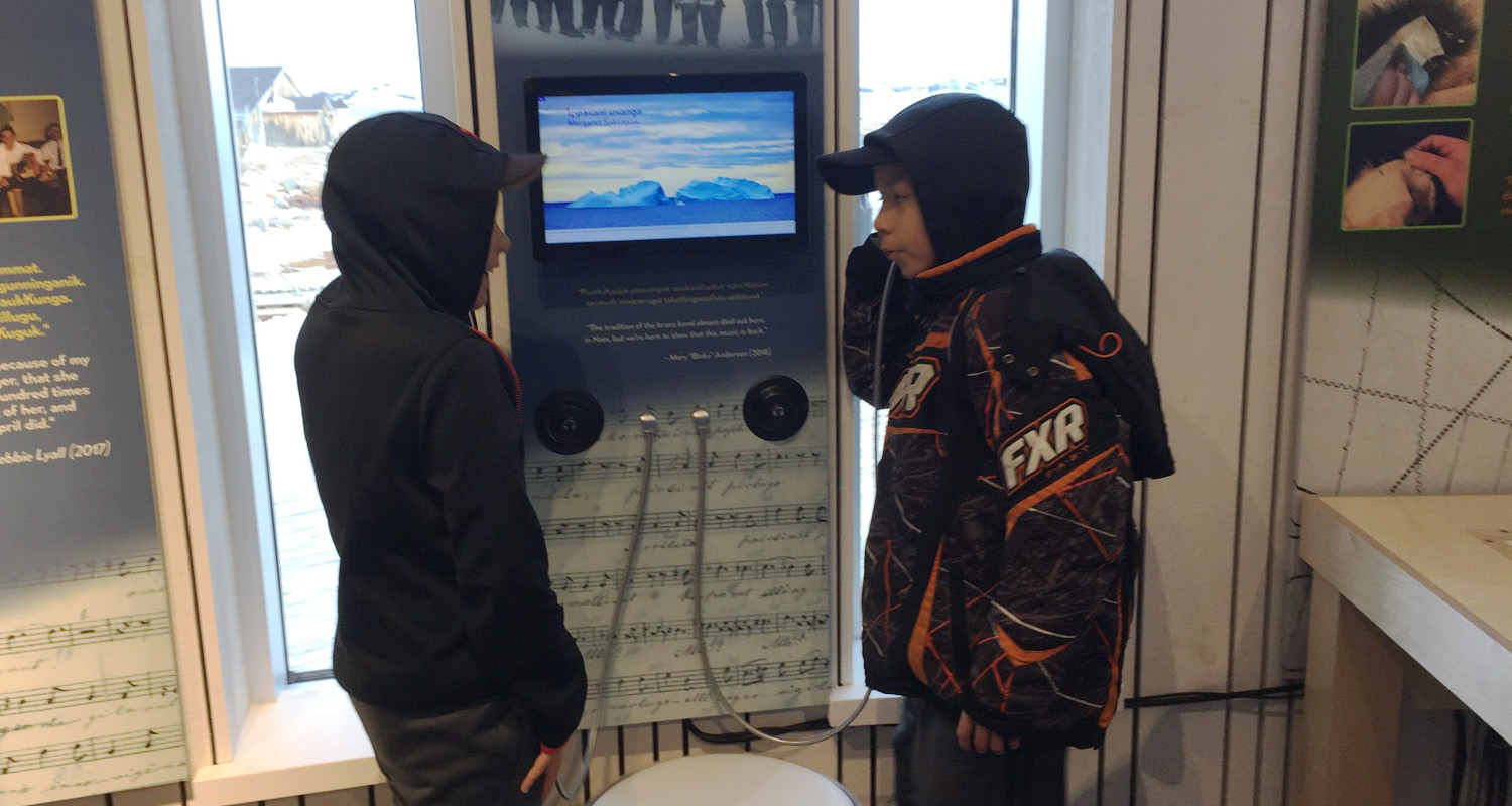 Kids listening to screen using Single Cup Headphones at Illusauk Cultural Centre